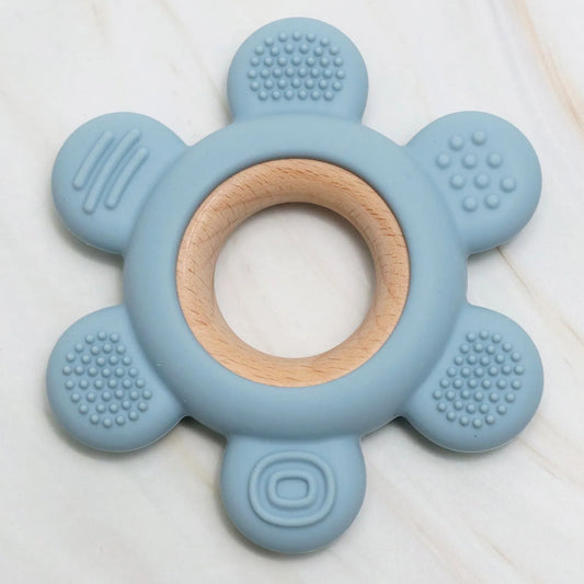 Accessoire de dentition K-BABY en silicone bleu ciel et bois naturel, adapté aux bébés dès 3 mois